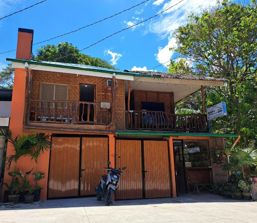 a motorcycle parked in front of a building with a balcony at RYJ's Inn in Siquijor