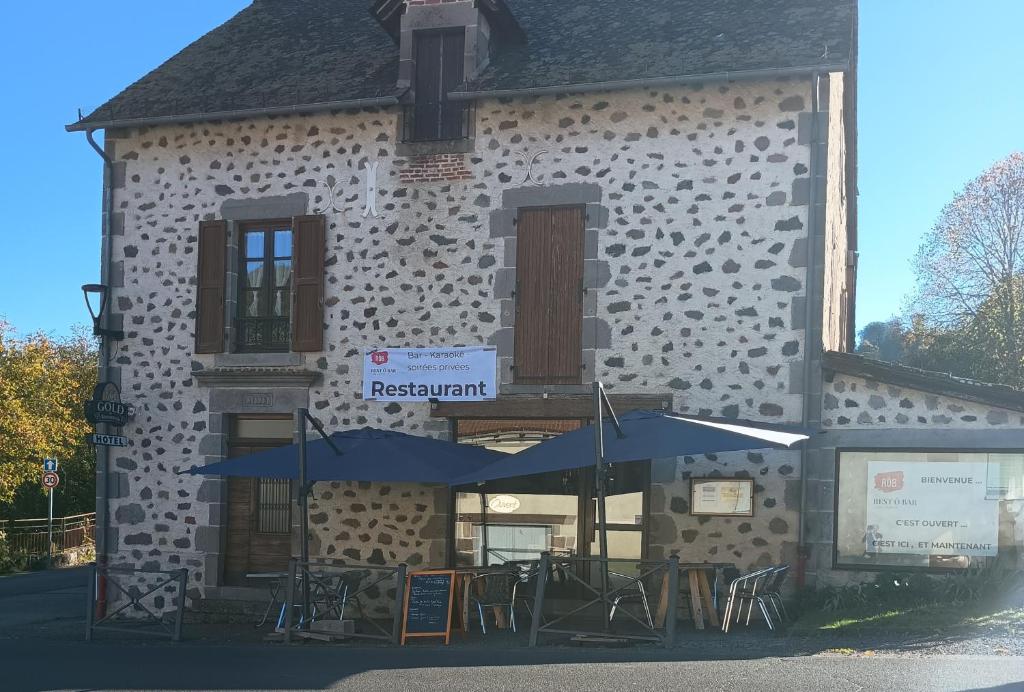 a building with tables and umbrellas in front of it at Rest'ô Bar Les 2 Ponts in Saint-Simon
