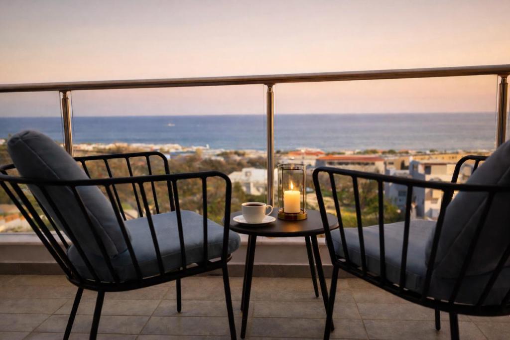 a balcony with two chairs and a candle on a table at Alkion Villa Sea View, Olive Tree Garden & Spacious Terrace in Rhodes Town