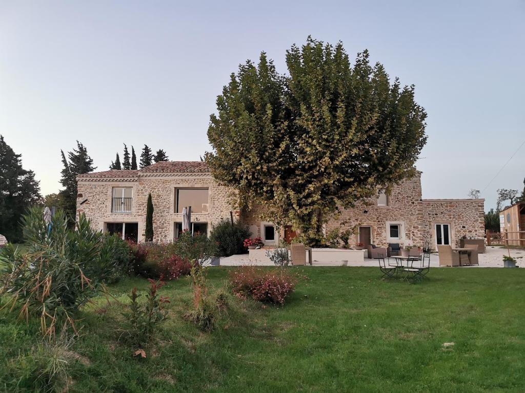 a large brick house with a green yard at La petite plaine in Clansayes