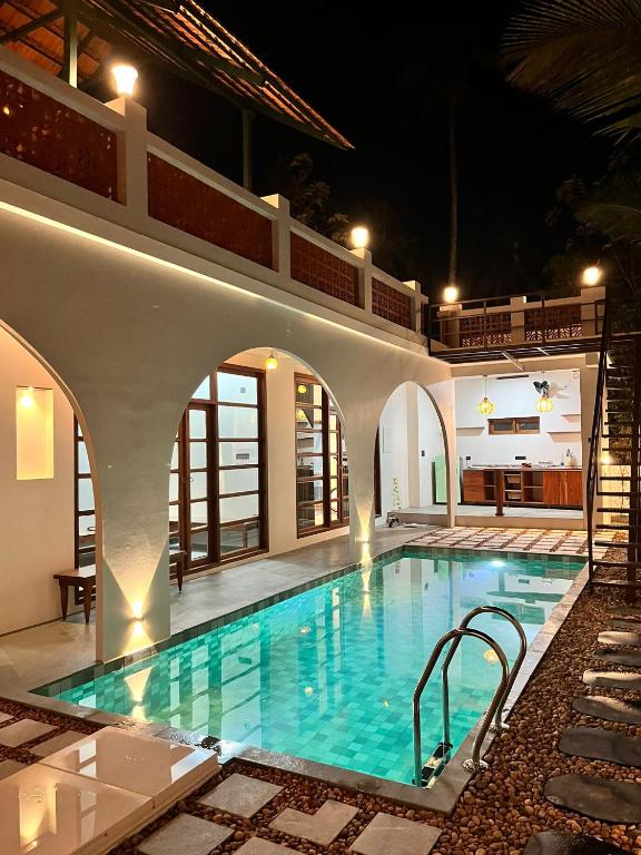 a swimming pool in a villa at night at Nilah Private Pool Villa in Kappil