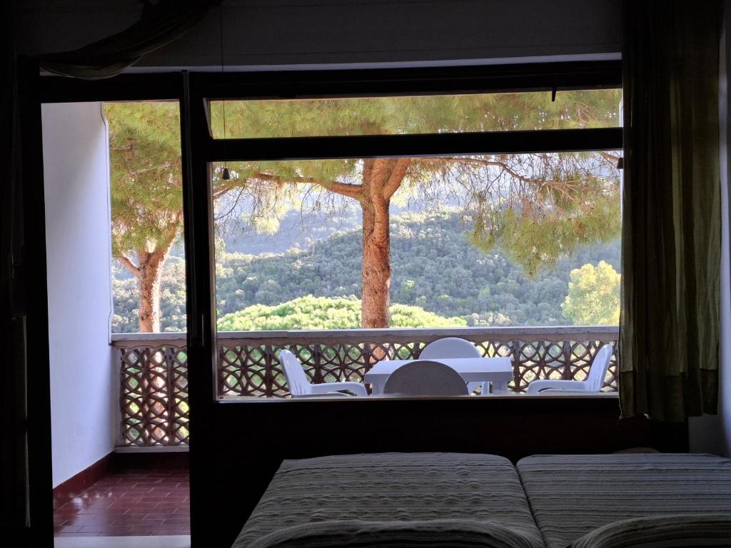 a room with a view of a balcony with a table and chairs at Residence Napoleon - MV in Procchio