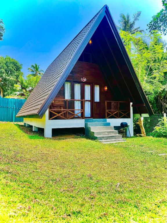 a small house with a gambrel roof at Soluna Cove luxury Cabanas Hikkaduwa in Hikkaduwa