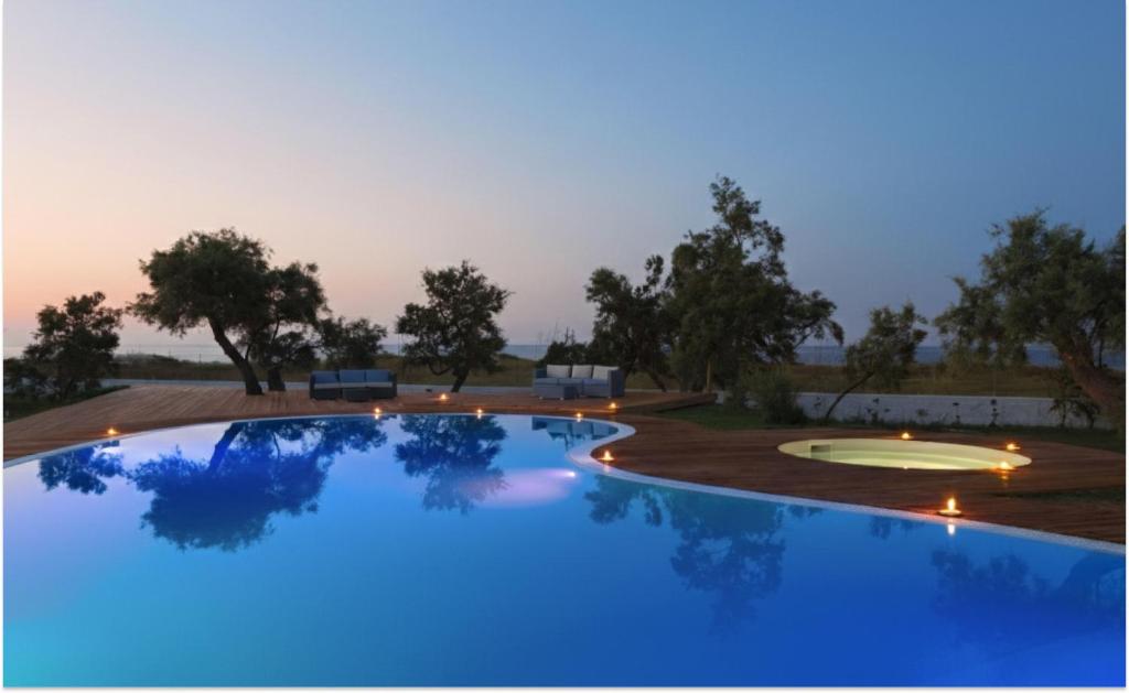 a large swimming pool with blue lights in a yard at Spiaggiabella Resort in Torre Rinalda