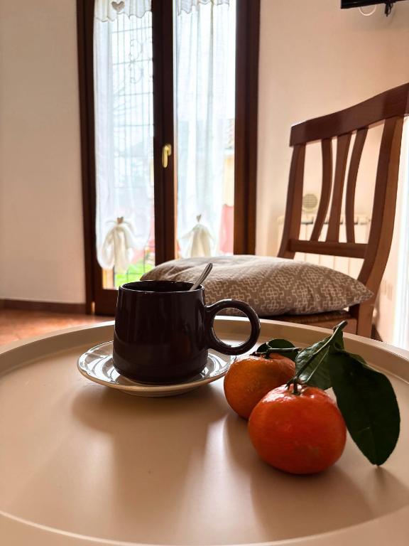 two oranges and a coffee cup on a table at Aura LT - Vicinissima all'aeroporto in Fiumicino