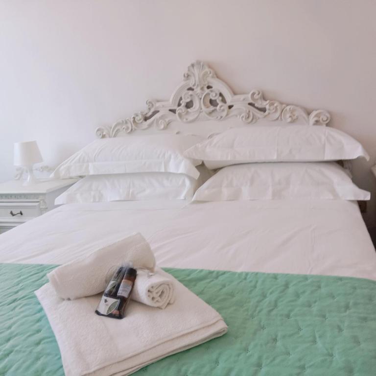 a white bed with a towel on top of it at The Shamrock House in Palazzolo Acreide