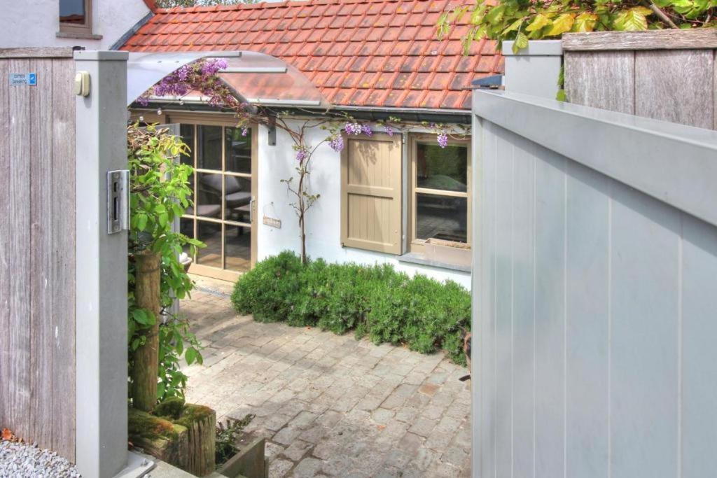 a white fence in front of a house at The River Cottage in Middelkerke