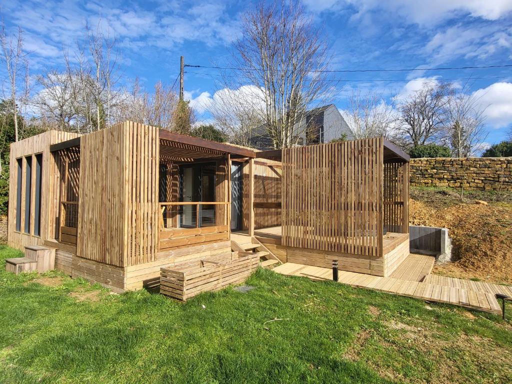 a wooden house sitting on top of a lush green field at La cabane des folies in Montmédy
