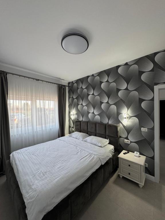 a bedroom with a large bed with a gray headboard at DE Apartment in Rădăuţi