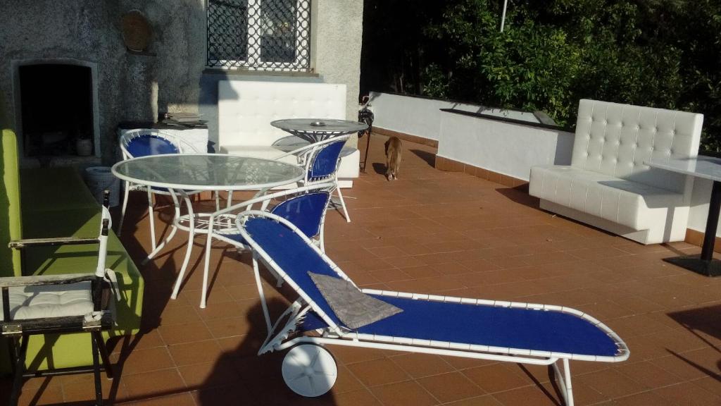 a blue and white chair and a glass table on a patio at Ghirindoun in Celle Ligure