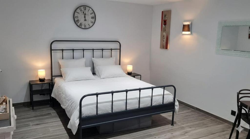 a bedroom with a bed with a clock on the wall at Chez fina in Ath