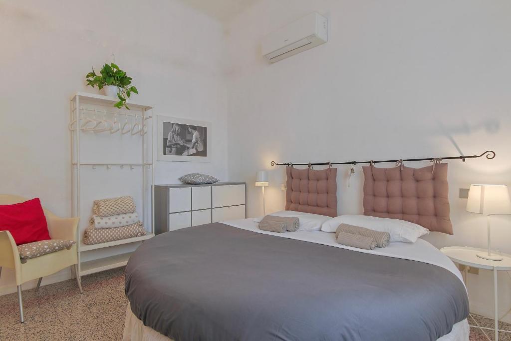 ein Schlafzimmer mit einem großen Bett und zwei Stühlen in der Unterkunft B&B Cristina e Stefano in Pisa