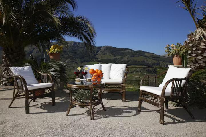 a patio with two chairs and a table with flowers on it at Casa Luce in Caltabellotta