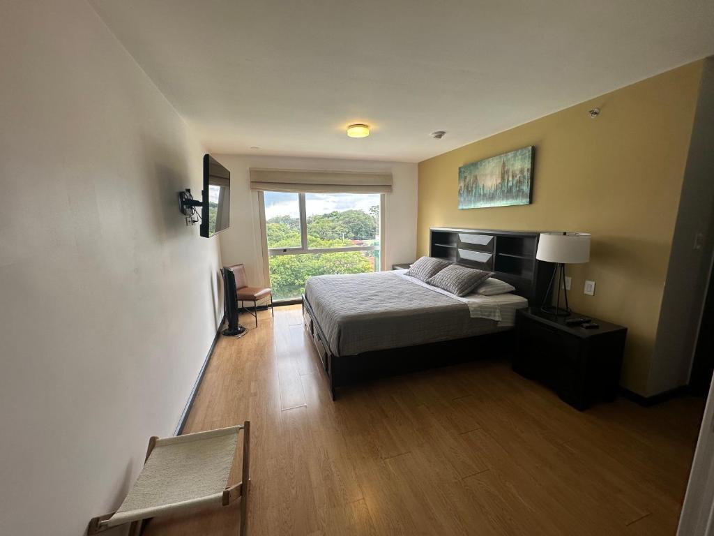 a bedroom with a bed and a window at Charming Two Bedroom with balcony in San José