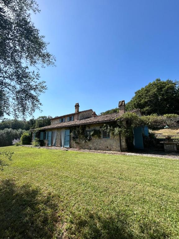 an old stone house with a large grass field at Casale delle Querce in Amelia