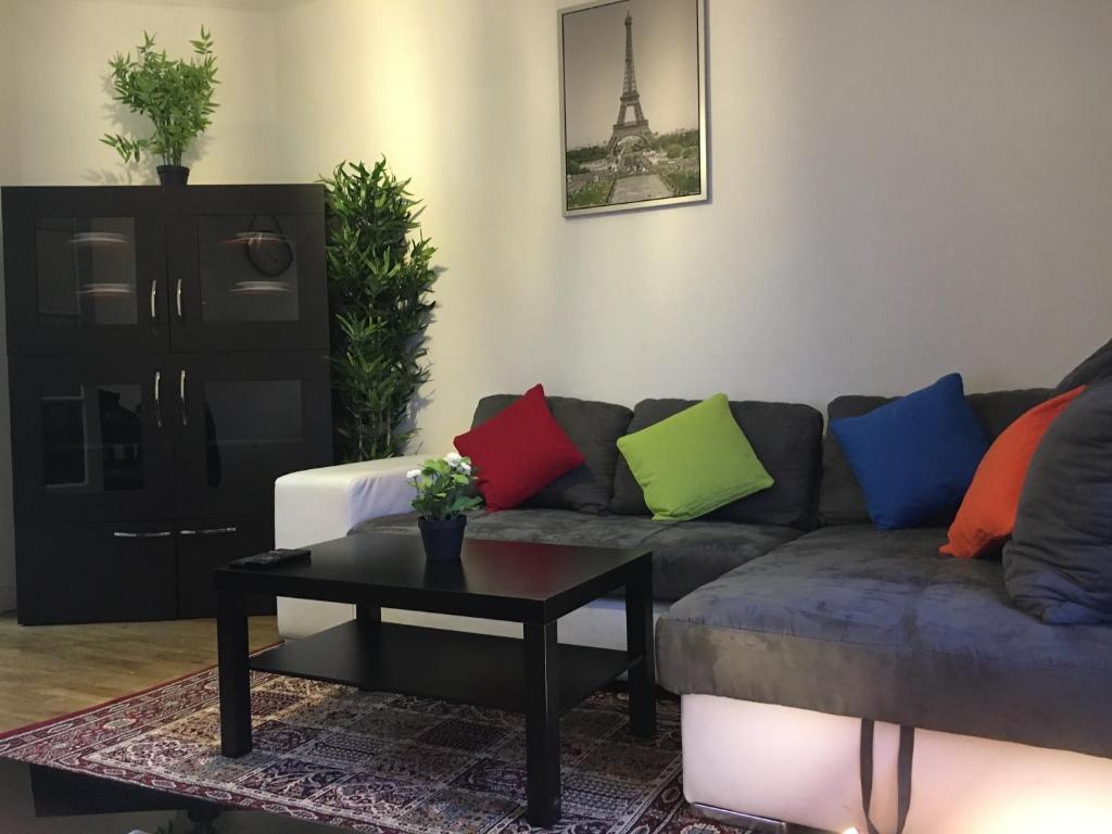 Una sala de estar con un sofá con almohadas de colores. en Tour Eiffel, Paris Expo - Parc des Princes Apartement, en París