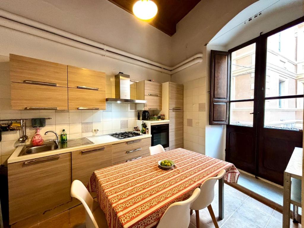 a kitchen with a table and chairs and a kitchen with a table and a window at Vintage Flat, Centro storico, Cagliari in Cagliari
