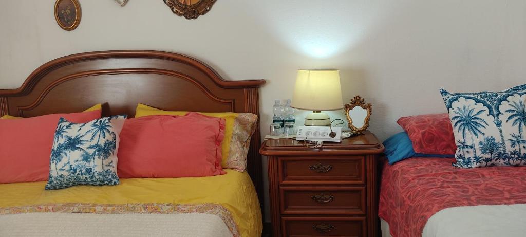 a bedroom with two beds and a lamp on a night stand at Amabile Guesthouse in Milis