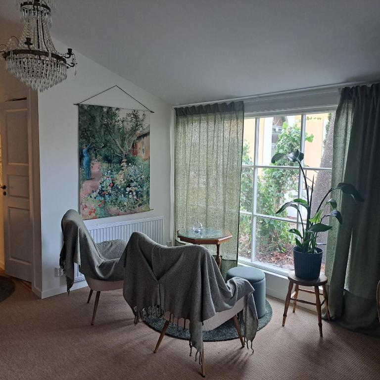 a living room with chairs and a large window at Cute gardenhouse close to Stockholm City in Solna