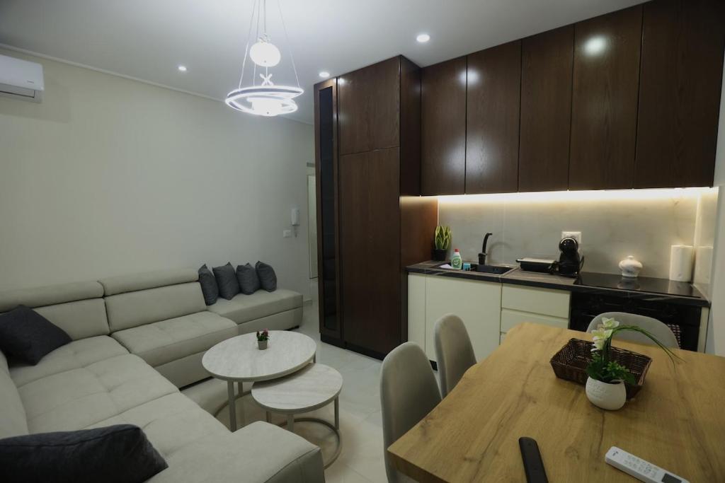 a living room with a couch and a table and a kitchen at The Swan Nest 2 in Pogradec
