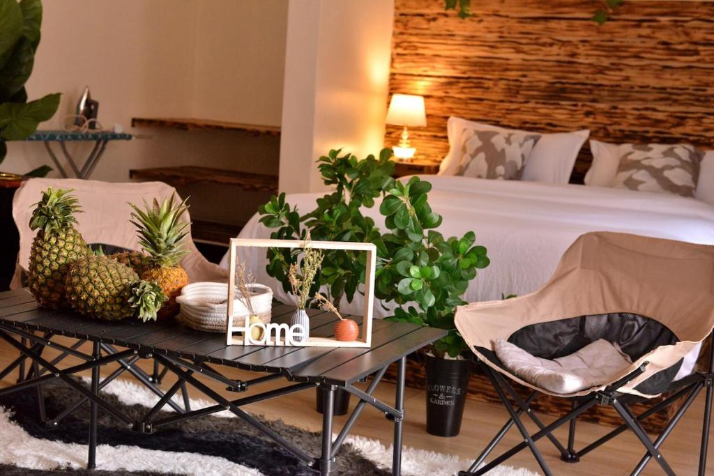 a bedroom with a bed and a table with fruits and plants at Peryn Suites Kinubi, Hoima City, Uganda in Hoima