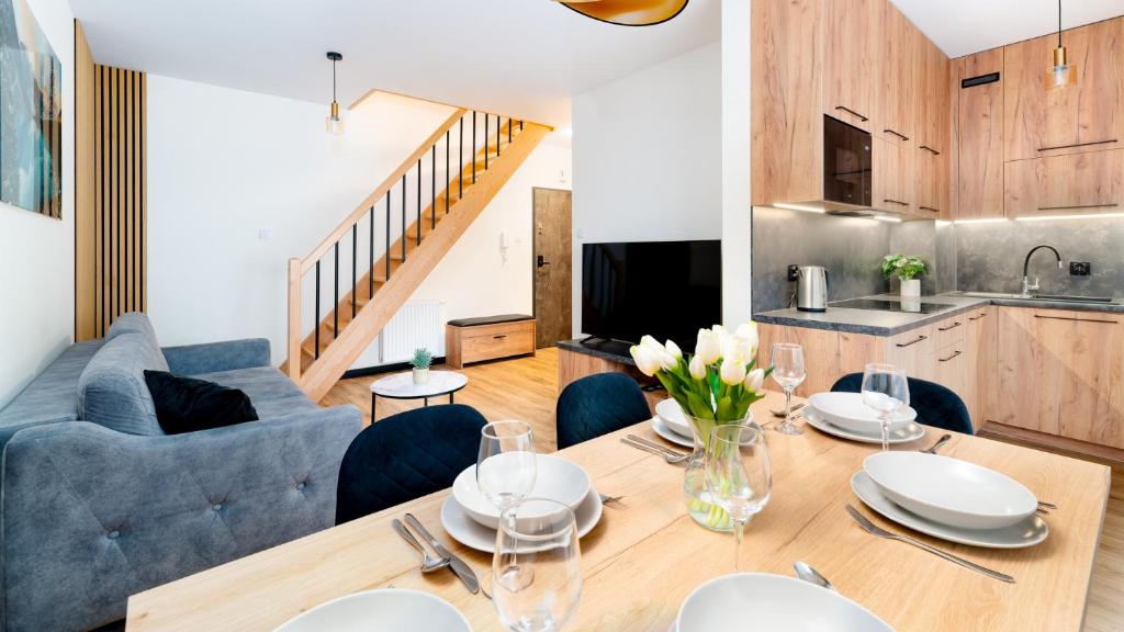 a dining room with a table and a blue couch at Apartament Komfort Lux in Karpacz