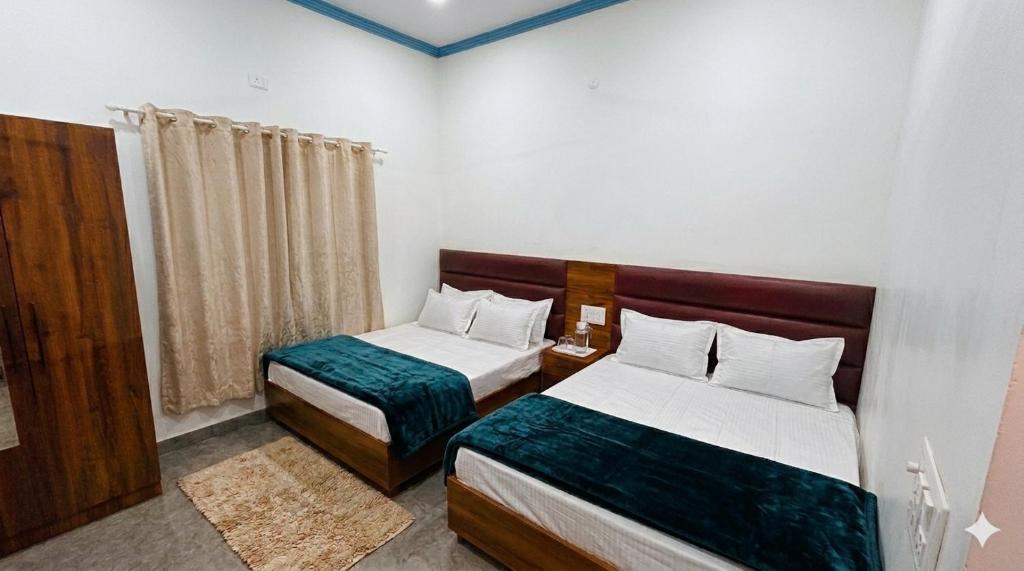 a hotel room with two beds and a window at Skyline Hotel in Uttarkāshi