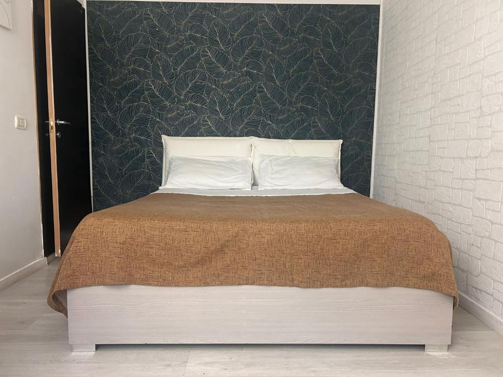 a bed with two pillows and a black wall at Camera con Bagno ingresso autonomo in Taranto