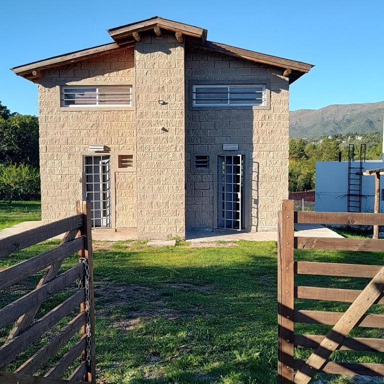 a brick house with a fence in front of it at Kima III in Huerta Grande