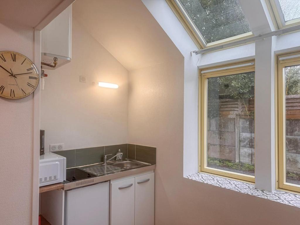 a kitchen with a sink and a clock on the wall at Studio Neuf Centre - Chambre Séparée - Parking in Bressuire