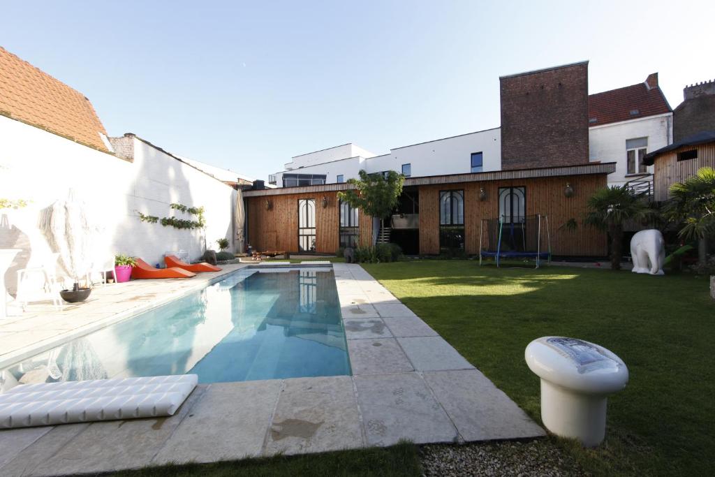 a backyard with a swimming pool and a house at Koto Garden Suites in Antwerp