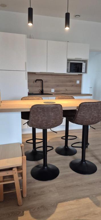a kitchen with a wooden table and two chairs at Appartement coquet proche plage in Berck-sur-Mer