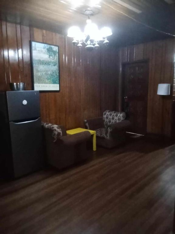 a living room with two chairs and a couch and a table at Jenny's transient house in Baguio