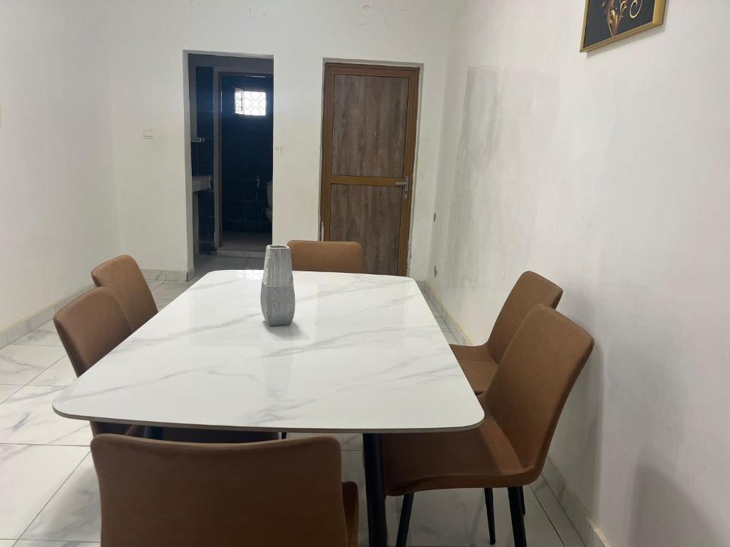 a white table with chairs and a vase on it at Duplex sahrawi in Nouakchott