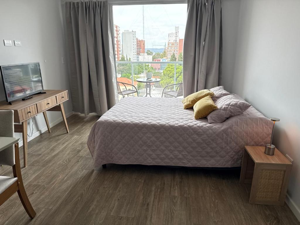 a bedroom with a bed and a large window at Estudio 63 in Neuquén