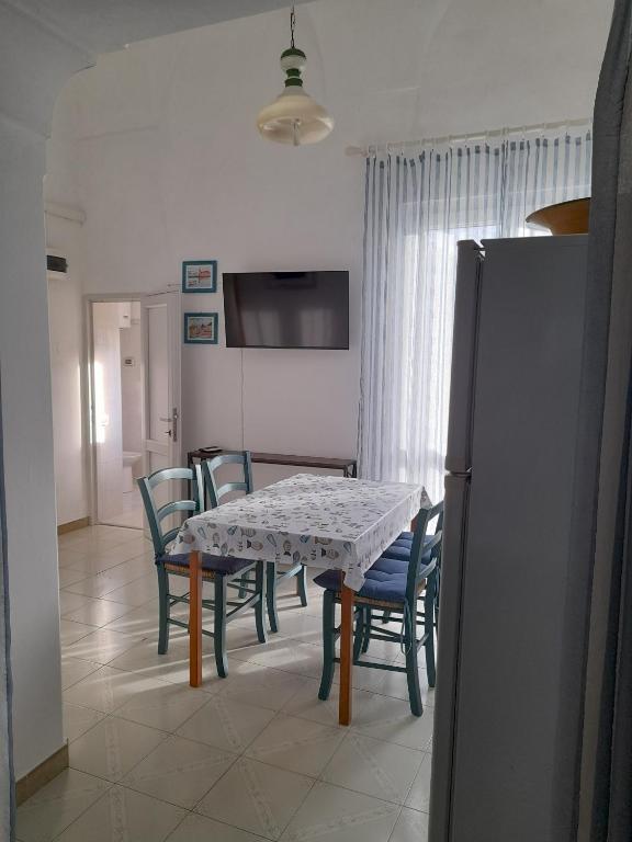 a dining room with a table and chairs and a refrigerator at Poseidone Ponza in Ponza