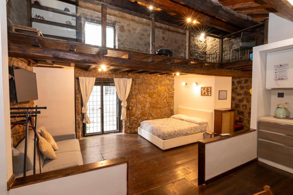 a loft bedroom with a bed and a tv at Maestosa Maison della Cattedrale, 3 piani storici tutti per voi! in Sutri