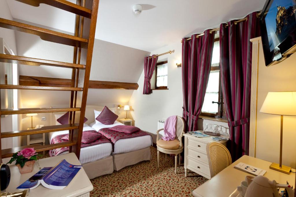 a bedroom with a bunk bed and a desk at Auberge Saint Pierre in Le Mont Saint Michel