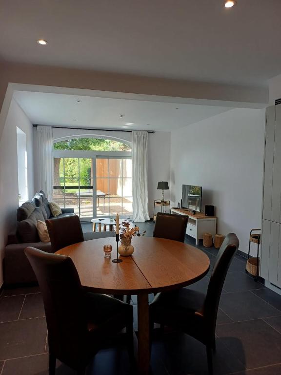 a living room with a wooden table and chairs at Gastenverblijf Onder een Oude Eik in Tongeren