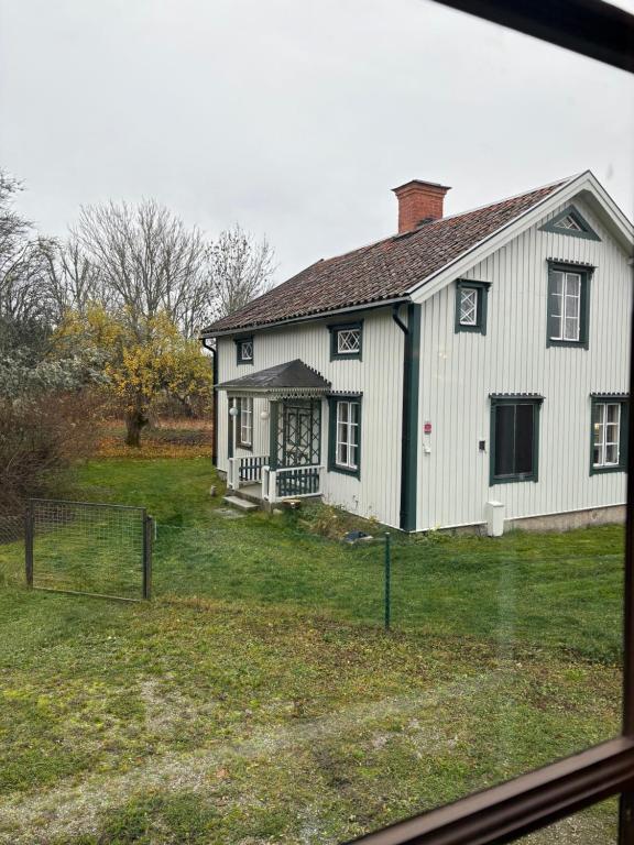 a white house with a fence in front of it at Ranchen B&B in Enköping