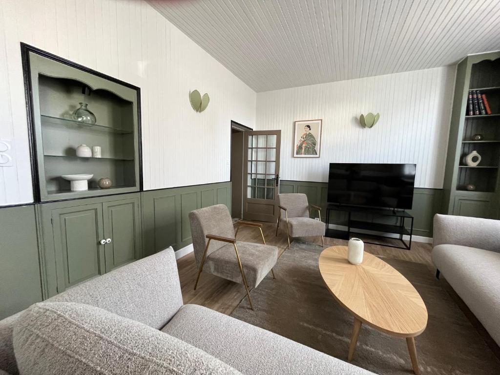 a living room with a couch and chairs and a television at Maison WILSON in Blois