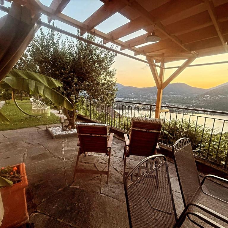 a patio with chairs and a view of the water at LA TERRAZZA appartamento di vacanza in Collina d'Oro