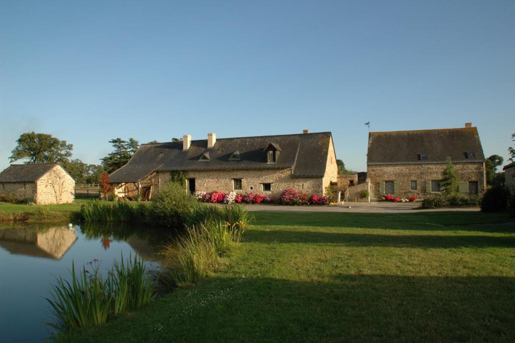 an old house with a pond in front of it at Grand Mainguet in Saint-Lambert-la-Potherie