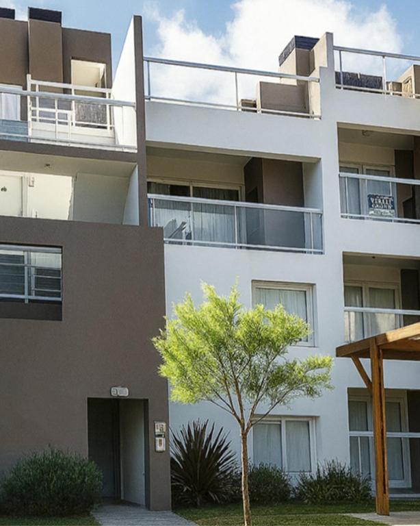 an apartment building with a tree in front of it at Terraza Marina V in Pinamar