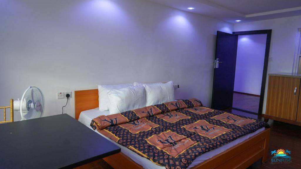 a bedroom with a bed and a table in it at SunRise Beach Resort in Iberekodo