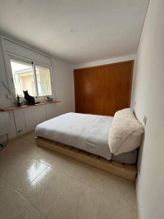 a bedroom with a bed and a cat sitting in a window at Hilda's Queen Room private bathroom in Roses