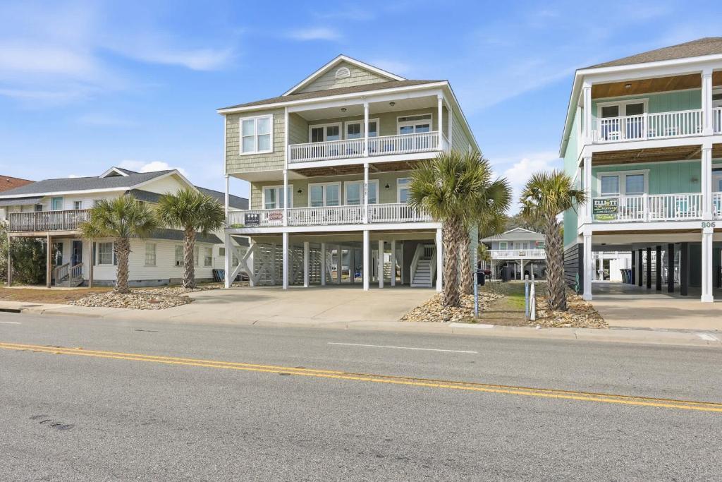 a building with palm trees in front of a street at Anchor Down Luxury Ocean View Beach House w Pool in Myrtle Beach