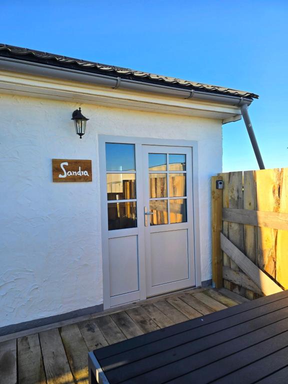 a white building with a door and a sign on it at Sandra Fewo nähe Rømø in Bredebro in Bredebro