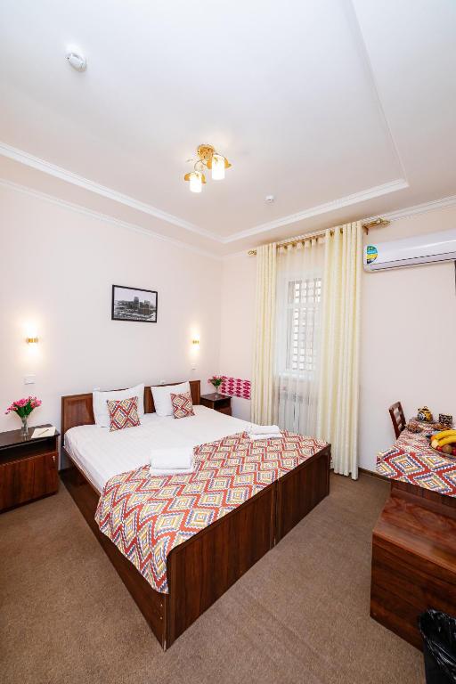 a hotel room with two beds and a window at Caravan Boutique Ichan Kala in Khiva