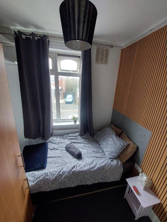 a small bedroom with a bed and a window at Lindi Property Affordable Single Room in Wyken